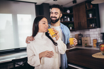Young couple making breakfast at home. Loving couple having fun in kitchen.