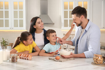 Obraz na płótnie Canvas Happy family cooking together at table in kitchen. Adoption concept