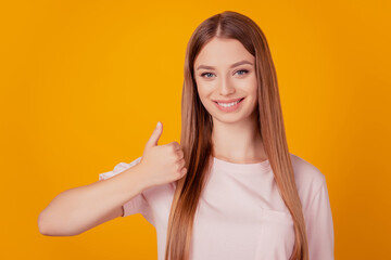 Portrait of cheerful positive nice lady raise thumb up approve your choice on yellow background