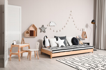 Cute kids room with stylish comfortable floor bed and toys. Montessori interior