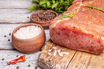 A piece of raw pork loin, marinated fresh meat with spices