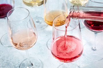 Vibrant rose wine pour in a glass. Wine tasting event at a bar or a party