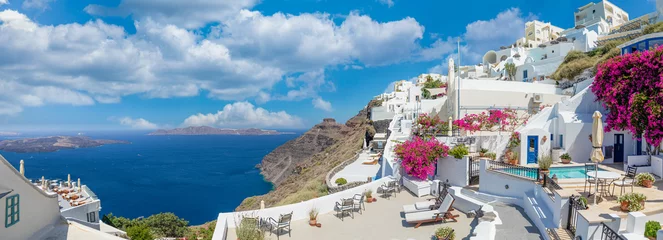 Poster Sunny in Oia caldera panorama on Santorini island, Greece. Famous travel summer vacation destination. Flowers, white blue architecture, sunlight peaceful summer vibe. Inspirational panoramic landscape © icemanphotos