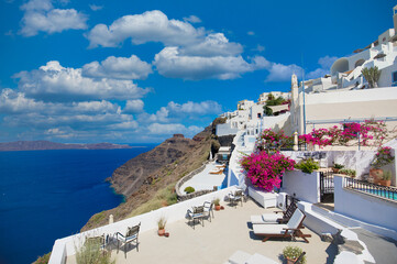 Summer vacation panorama, luxury famous Europe destination. White architecture in Santorini, Greece. Perfect travel scenery with pink flowers and cruise ship in sunlight and blue sky. Amazing scenic