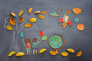 Back to school concept. Top view banner of boy and girl next to tree sketch with autumn dry leaves over classroom blackboard background