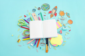 Back to school concept. Top view image of open empty notebook and student stationery over pastel...