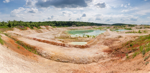 Panorama of abandoned kaolin quarry partly filled with water