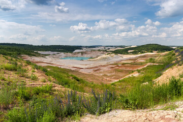 Abandoned kaolin pit with small turquoise quarry lake in center - obrazy, fototapety, plakaty