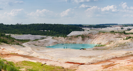 Turquoise quarry lake in abandoned kaolin pit in summer day