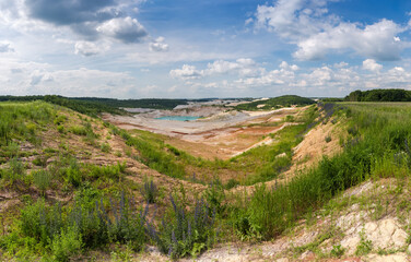Fototapeta na wymiar Panorama of abandoned kaolin pit with small turquoise quarry lake