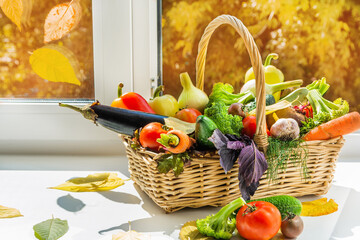 There is a large basket of vegetables by the window. A set of vegetables vegetables for vegetarian options. Vegetables are harvested in autumn