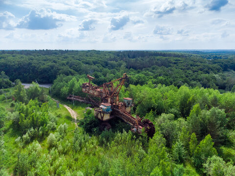 Old abandoned bucket wheel excavator among the trees, aerial view