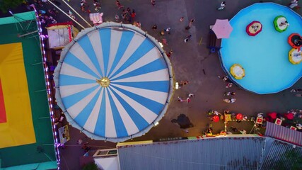 amusement park aerial view, merry go round spinning, view from above, colorful urban luna park, fairgrounds in the city