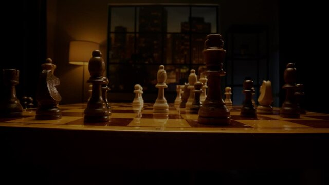 Skilled chessman hand moves white bishop on chessboard