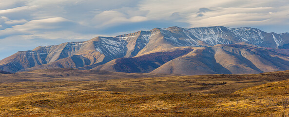 Autumn landscape in Patagonia: hills and mountains with some freshly fallen snow rising from the...