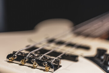 Close-up detail of bass guitar body on blurred background.
