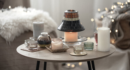Home cozy composition with flaming candles in the interior of the room.