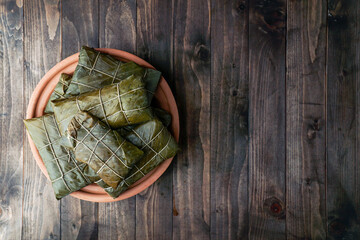 tamales colombianos, cocina mexicana colombiana, los tamales de la costa, en banana leaf, corn dough stuffed with a stew of pork