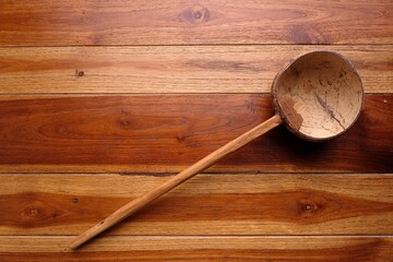 Ladle scooping coconut water on the wooden 