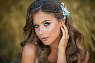 Fototapeta premium beautiful young bride in a wheat field at sunset