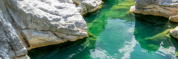 Quiet turquoise river stream along the tectonic rocks