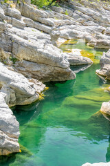 Fototapeta na wymiar Quiet turquoise river stream along the tectonic rocks