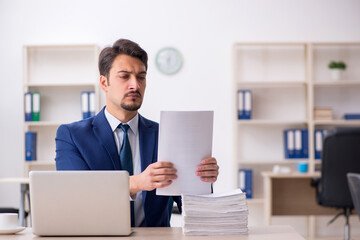 Young male employee and too much work in the office