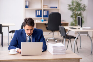 Fototapeta premium Young male employee and too much work in the office