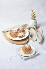 luxury home made chilled vanilla cream puff pastry choux with sugar powder on wood plate and cloth in white marble background dessert halal menu