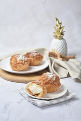 luxury home made chilled vanilla cream puff pastry choux with sugar powder on wood plate and cloth in white marble background dessert halal menu