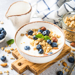 Yogurt with granola and fresh berries at stone table. Healthy food, snack or breakfast.