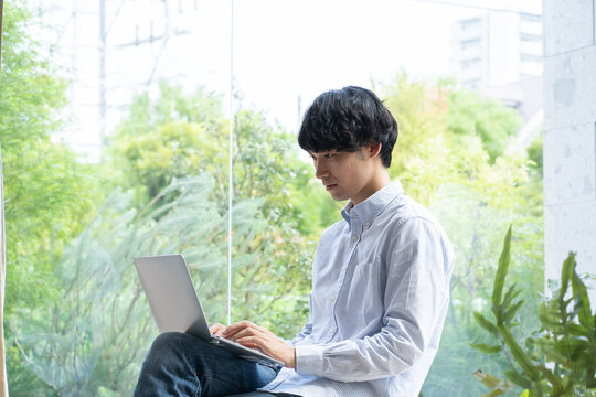 家で仕事をする若い日本人男性