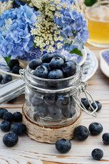 Glass jar with blueberries on the table.