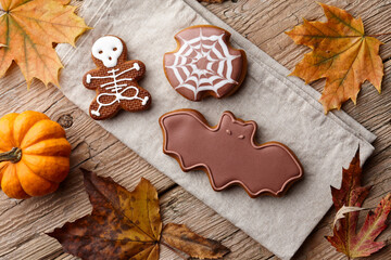 Halloween gingerbread cookies and autumn leaves on planks