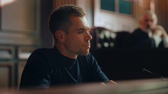 Court of Law and Justice Trial Stand: Portrait of Handsome Male Witness Giving Testimony to Judge, Jury. Speech of Hardened Criminal Denying Charges, Lying, Accusing Victims, Committing Perjury