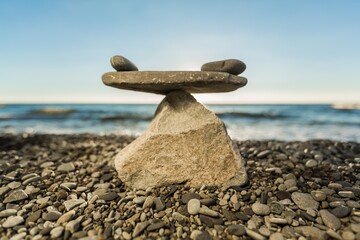 Balancing sea stone on beach background