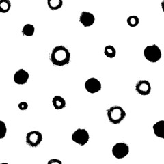 Seamless pattern with black circles scattered on white background. Hand drawn polka dot vector ornament. Modern abstract design for print or textile. Different grunge effect rounded spots and circles