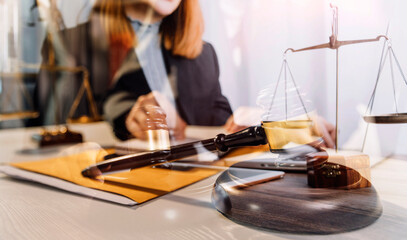 Justice and law concept.Male judge in a courtroom with the gavel, working with, computer and docking keyboard, eyeglasses, on table in morning light