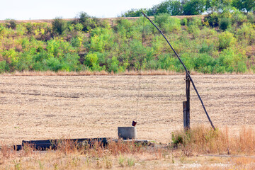 Ancient water well made by wooden logs . Water source on arid land