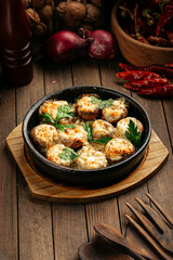 Georgian baked mushrooms with suluguni cheese on a wooden background