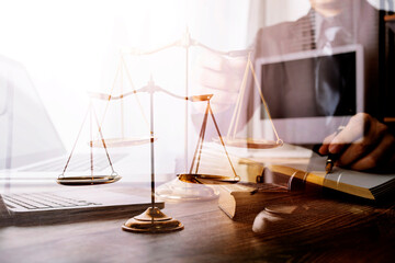 Justice and law concept.Male judge in a courtroom with the gavel, working with, computer and docking keyboard, eyeglasses, on table in morning light