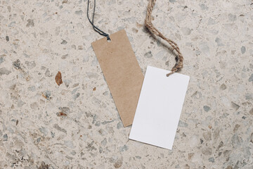 Empty paper gift tags, price labels with ropes on terrazzo background. Marble stone texture. Modern...