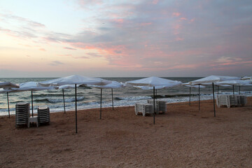 Uncrowded beach area with sun loungers and parasols.