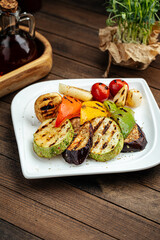 Assorted grilled vegetables plate garnish on a wooden background
