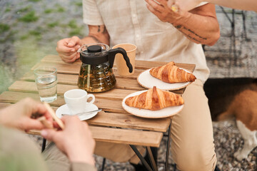 Man preparing eating croissants with his wife during the romantic date