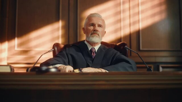Court of Law Trial: Portrait of Impartial Judge Reading Decision, striking Gavel. Justice Pronouncing Sentence. Judgment after Deliberation. Guilty, Not Guilty Verdict. Cinematic Concept Rule of Law