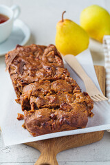 Pear bread on a wooden board. Autumn fruit pie, gray background