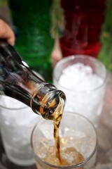 Close up of pouring soft drink with ice cubes