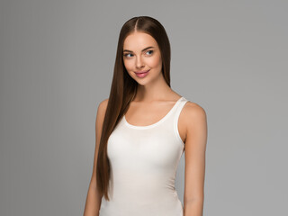 Obraz premium Beautiful woman with long smooth hair natural make up over gray background
