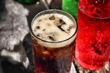 Soft drink cola red and green with ice cubes